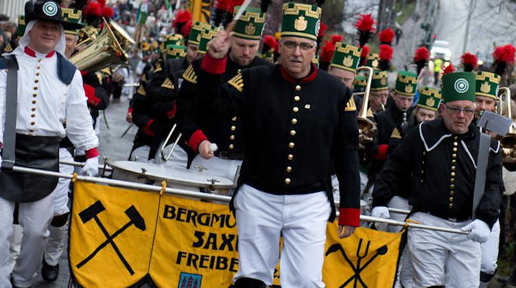 Teilnehmer der Bergparade in Freiberg (Sachsen) gehen in historischer Bergarbeiterkleidung durch die Altstadt. Foto: Arno Burgi/dpa-Zentralbild/dpa/Archivbild