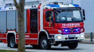 Ein Feuerwehrfahrzeug fährt mit Blaulicht zu einem Einsatz. Foto: Jens Büttner/dpa-Zentralbild/ZB/Symbolbild