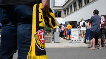 Fußballfans und Bürger der Stadt stehen zum Auftakt der gemeinsamen Impfaktion an. Foto: Robert Michael/dpa-Zentralbild/dpa