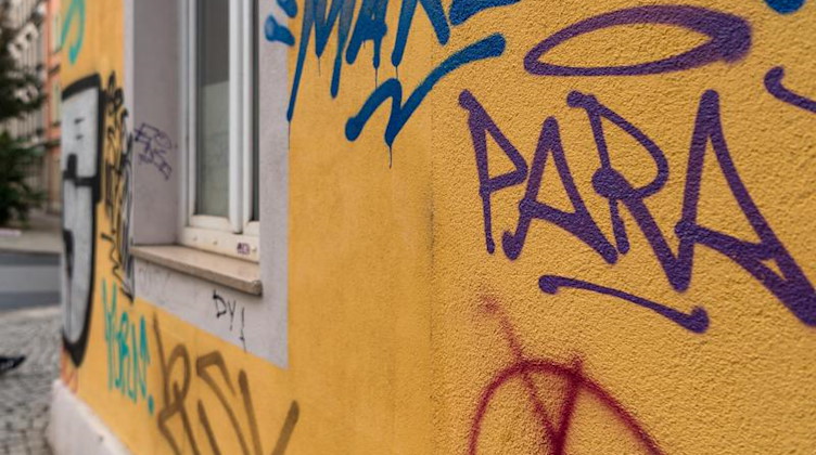 Graffiti an der Fassade eines Wohnhauses. Foto: Monika Skolimowska/zb/dpa/Symbolbild