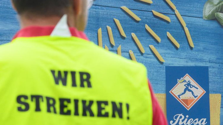 Ein Gewerkschaftsmitarbeiter steht während eines Streiks vor dem Werk der Teigwaren Riesa GmbH. Foto: Robert Michael/dpa-Zentralbild/dpa/Archiv