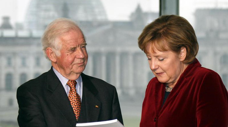 Biedenkopf überreicht am 20.12.2006 den Jahres-Abschlussbericht der Kommision an Bundeskanzlerin Merkel. Foto: Wolfgang Kumm/dpa/Archivbild