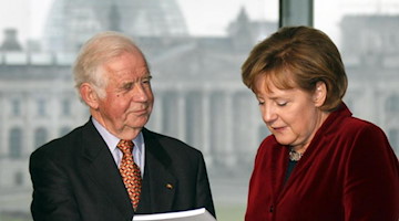 Biedenkopf überreicht am 20.12.2006 den Jahres-Abschlussbericht der Kommision an Bundeskanzlerin Merkel. Foto: Wolfgang Kumm/dpa/Archivbild