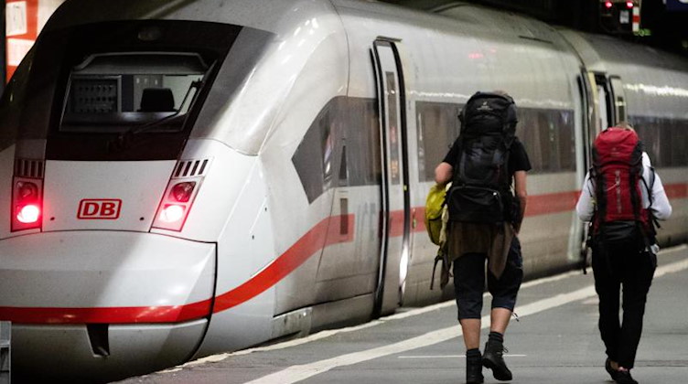 Fahrgäste laufen zu einem ICE-Zug. Foto: Christoph Schmidt/dpa/Archivbild