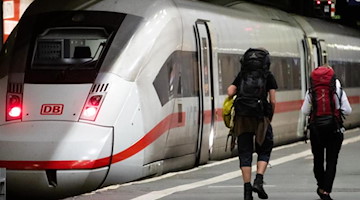 Fahrgäste laufen zu einem ICE-Zug. Foto: Christoph Schmidt/dpa/Archivbild