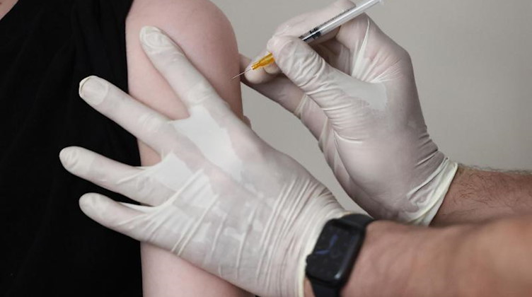 Ein Hausarzt impft einen Jugendlichen in seiner Praxis. Foto: Oliver Berg/dpa/Symbolbild