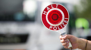 Ein Polizist hält bei einer Verkehrskontrolle eine Polizeikelle in der Hand. Foto: Jonas Güttler/dpa/Symbolbild
