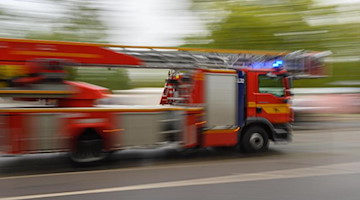 Ein Feuerwehrfahrzeug mit Drehleiter fährt zu einem Einsatz. Foto: Robert Michael/dpa-Zentralbild/ZB/Symbolbild