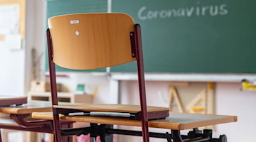«Coronavirus» steht auf einer Tafel in einem leeren Klassenzimmer. Foto: Armin Weigel/dpa/Symbolbild