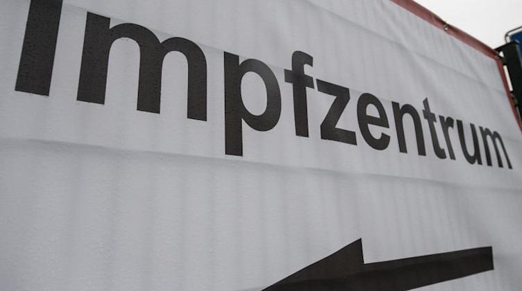 Ein Schild weist den Weg zu einem Impfzentrum. Foto: Boris Roessler/dpa/Symbolbild