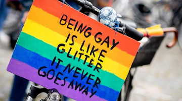 «Being gay is like glitter - it never goes away» steht zum Christopher Street Day auf einem Schild. Foto: Hauke-Christian Dittrich/dpa/Symbolbild