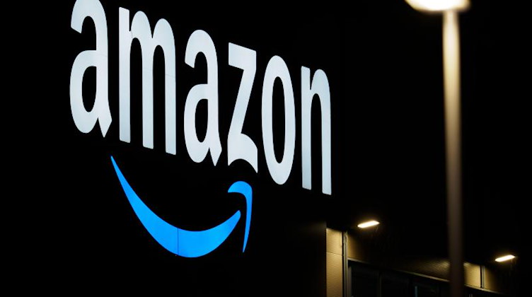 Das Logo von Amazon läuchtet in der Nacht. Foto: Soeren Stache/dpa-Zentralbild/dpa