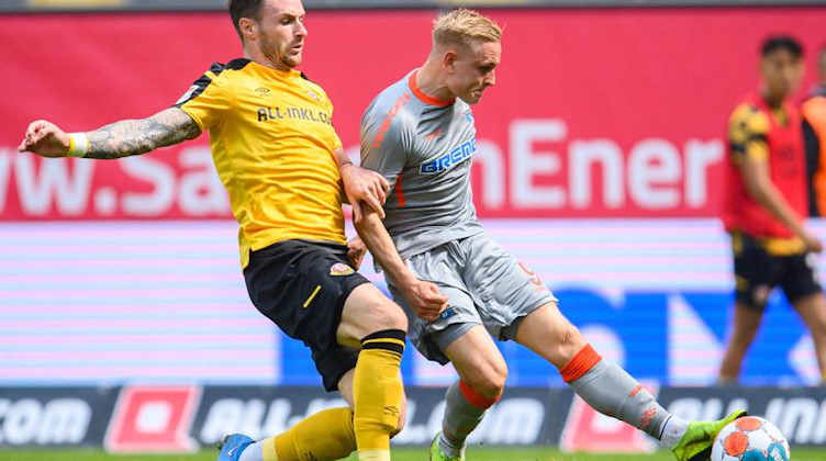 Paderborns Kai Pröger (r) erzielt gegen Dynamos Michael Sollbauer das Tor zum 0:2. Foto: Robert Michael/dpa-Zentralbild/dpa