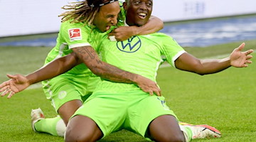 Wolfsburgs Jerome Roussillon jubelt nach seinem Treffer zum 1:0 mit Kevin Mbabu (l). Foto: Swen Pförtner/dpa