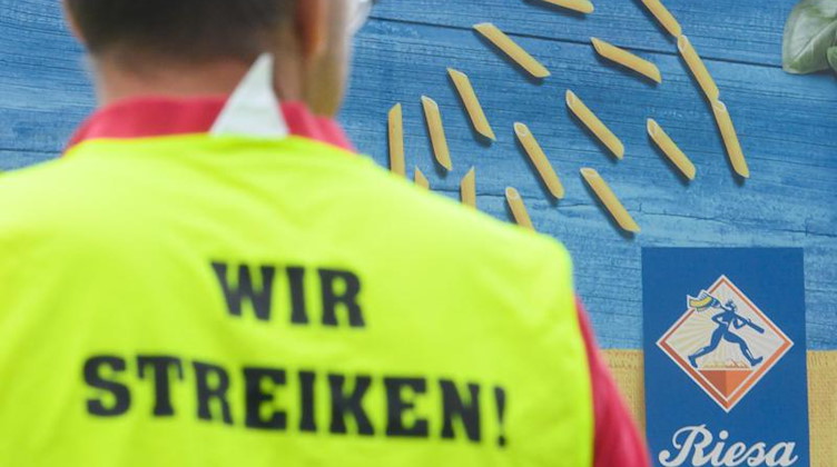 Ein Gewerkschaftsmitarbeiter steht während eines Streiks vor dem Werk der Teigwaren Riesa GmbH. Foto: Robert Michael/dpa-Zentralbild/dpa/archivbild