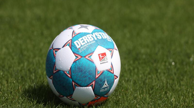 Ein Spielball liegt auf dem Rasen. Foto: Guido Kirchner/dpa/Symbolbild