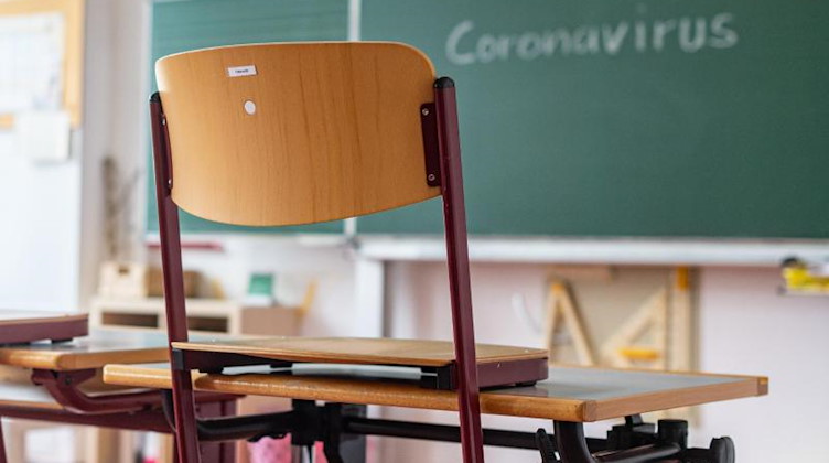 «Coronavirus» steht auf einer Tafel in einem leeren Klassenzimmer. Foto: Armin Weigel/dpa/Symbolbild