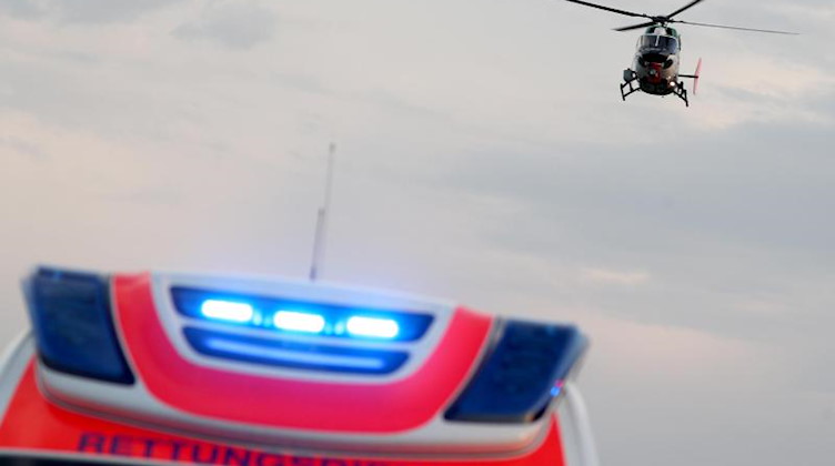 Ein Hubschrauber fliegt über einem Rettungswagen zu einem Unfallort. Foto: Jan Woitas/dpa-Zentralbild/dpa/Symbolbild