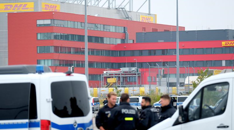 Polizisten stehen am Standort des Logistikers DHL am Flughafen Leipzig-Halle. Foto: Sebastian Willnow/dpa-Zentralbild/dpa