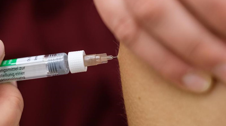 Eine Arzthelferin impft eine Patentin mit einer Spritze. Foto: Ole Spata/dpa/Symbolbild