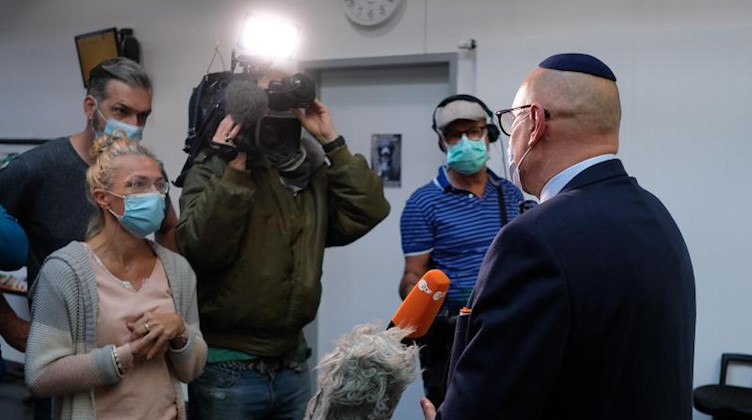 Uwe Dziuballa (r), Chef des jüdischen Restaurants „Schalom“, spricht im Amtsgericht mit Medienvertretern. Foto: Sebastian Willnow/dpa-Zentralbild/dpa