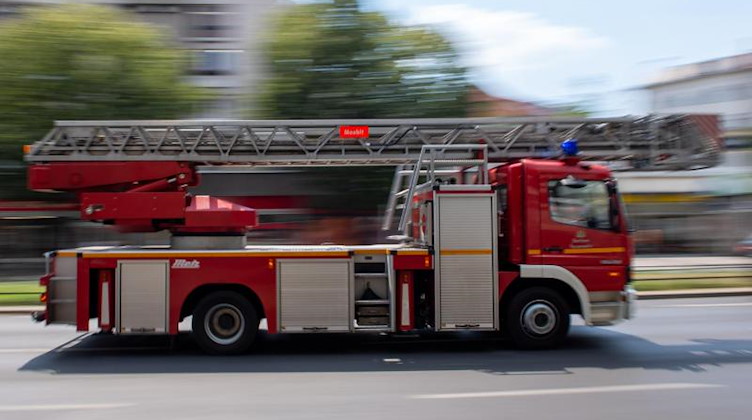 Ein Feuerwehrauto fährt mit Blaulicht zu einem Einsatz. Foto: Monika Skolimowska/dpa-Zentralbild/dpa/Symbolbild