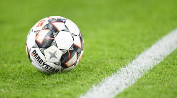 Ein Fußball liegt auf dem Rasen. Foto: Tobias Hase/dpa/Symbolbild