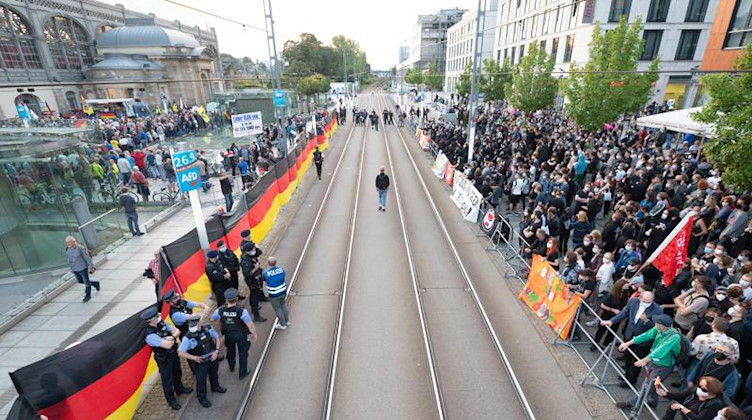 Gegendemonstranten (r) stehen während einer Kundgebung der islam- und fremdenfeindlichen Pegida-Bewegung (l) auf dem Wiener Platz vor dem Hauptbahnhof. Foto: Sebastian Kahnert/dpa-Zentralbild/dpa
