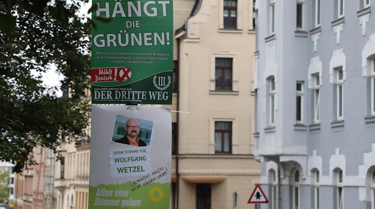 Ein umstrittenes Wahlplakat der Splitterpartei "III Weg" hängt über einem Plakat der Grünen. Foto: Bodo Schackow/dpa-Zentralbild/dpa