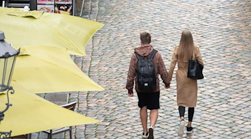 Passanten gehen an Restaurants auf der Münzgasse entlang. Foto: Sebastian Kahnert/dpa-Zentralbild/dpa/Archivbild