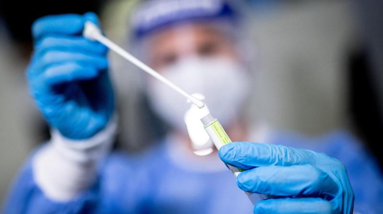 Eine medizinische Mitarbeiterin hält einen Tupfer für einen Abstrich für einen Corona-Test in der Hand. Foto: Matthias Balk/dpa/Symbolbild