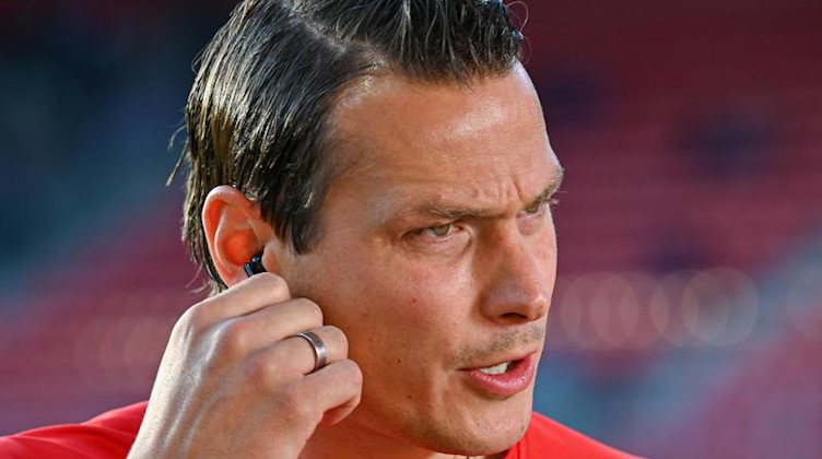 Aues Interims-Trainer Marc Hensel steht vor dem Spiel im Stadion. Foto: Armin Weigel/dpa