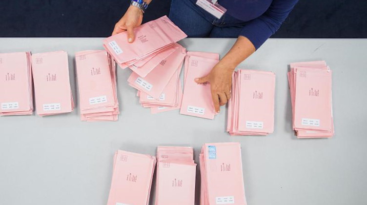 Eine Wahlhelferin sortiert Wahlbriefe. Foto: picture alliance / Rolf Vennenbernd/dpa/Symbolbild
