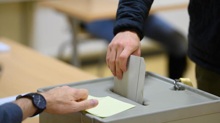 Ein Wähler wirft im Wahllokal seinen Stimmzettel in eine Wahlurne. Foto: Robert Michael/dpa-Zentralbild/dpa