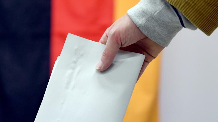 Ein Wähler wirft in einem Wahllokal seinen Stimmzettel in eine Wahlurne. Foto: Ralf Hirschberger/dpa-Zentralbild/dpa/Symbolbild