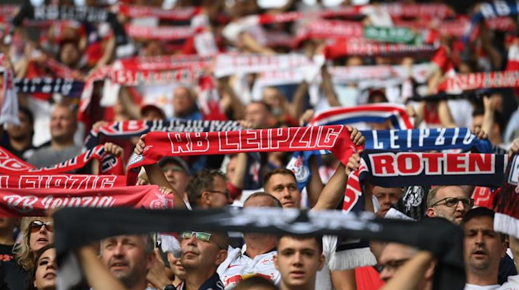 Fans vom RB Leipzig halten vor dem Spiel auf der Tribüne Leipzig-Schals hoch. Foto: Robert Michael/dpa-Zentralbild/dpa