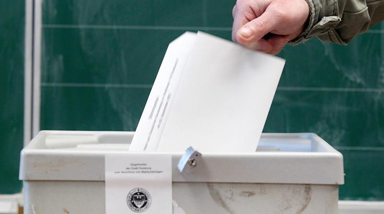 Ein Wähler wirft seinen Stimmzettel in einem Wahllokal in die Wahlurne. Foto: Roland Weihrauch/dpa/Symbolbild