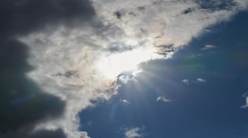 Die Sonne kommt hinter Regenwolken hervor. Foto: Annette Riedl/dpa/Symbolbild