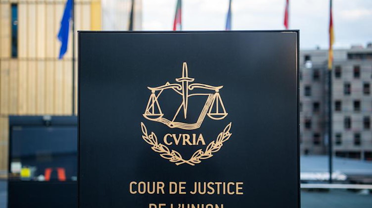 Ein Schild steht mit der Aufschrift «Cour de Justice de l'Union Européenne» steht vor dem EuGH. Foto: Arne Immanuel Bänsch/dpa/Symbolbild