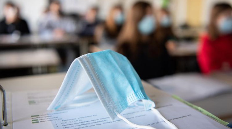 Eine Medizinische Maske liegt im Schulunterricht auf einem Tisch. Foto: Matthias Balk/dpa/Symbolbild