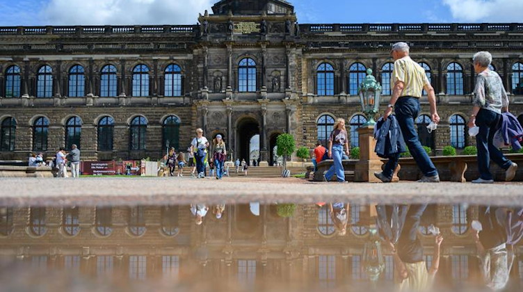 Touristen laufen durch den Dresdner Zwinger. Foto: Robert Michael/dpa-Zentralbild/dpa/Archiv