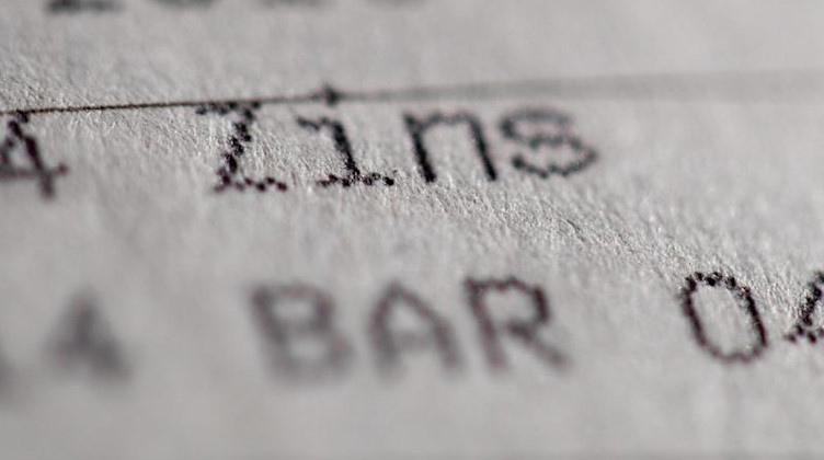 Die Einträge «Zins» und «Bar» sind in einem Sparbuch zu sehen. Foto: Daniel Karmann/dpa