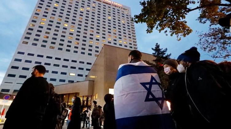 Ein Demonstrant trägt die Fahne Israels über den Schultern. Foto: Dirk Knofe/dpa