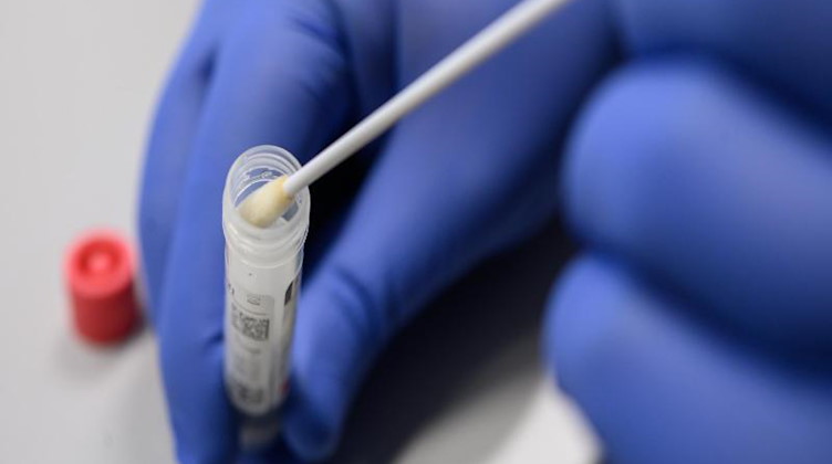 Ein Mann zeigt einen Abstrich für das Testverfahren auf das Virus Sars-CoV-2. Foto: Sebastian Gollnow/dpa/Symbolbild