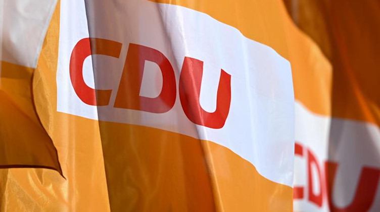 Das Parteilogo der CDU ist auf orangefarbenen Fahnen abgebildet. Foto: Hendrik Schmidt/dpa-Zentralbild/dpa/Symbolbild