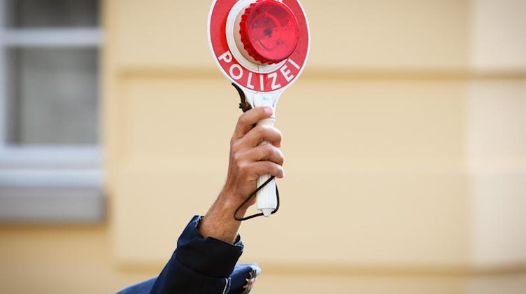 Ein Polizist hält eine Winkerkelle in der Hand. Foto: Soeren Stache/dpa-Zentralbild/dpa/Symbolbild