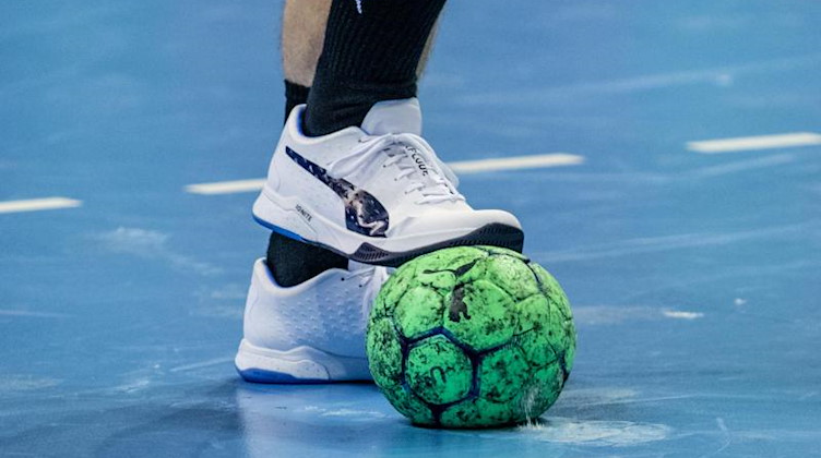 Ein Spieler hält einen Handball mit dem Fuß fest. Foto: Andreas Gora/dpa/Symbolbild
