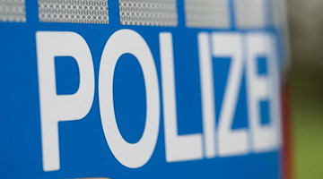 Das Wort "Polizei" steht auf der Karosserie eines Einsatzwagens. Foto: Marijan Murat/dpa/Symbolbild