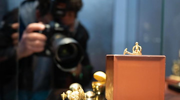 Ein Journalist fotografiert im Neuen Grünen Gewölbe das goldene Ei in einer Vitrine. Foto: Sebastian Kahnert/dpa-Zentralbild/dpa