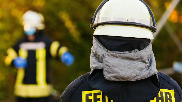 Einsatzkräfte der Feuerwehr in Schutzkleidung. Foto: Philipp von Ditfurth/dpa/Symbolbild